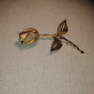 Giovanie: Gold tone single stem rose brooch.